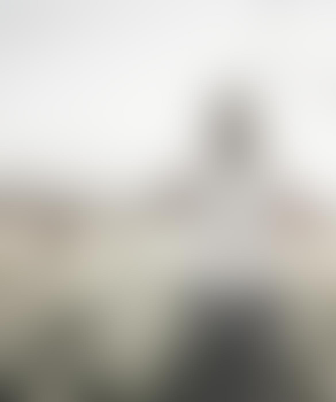 A blurry image of a person riding a motorcycle.